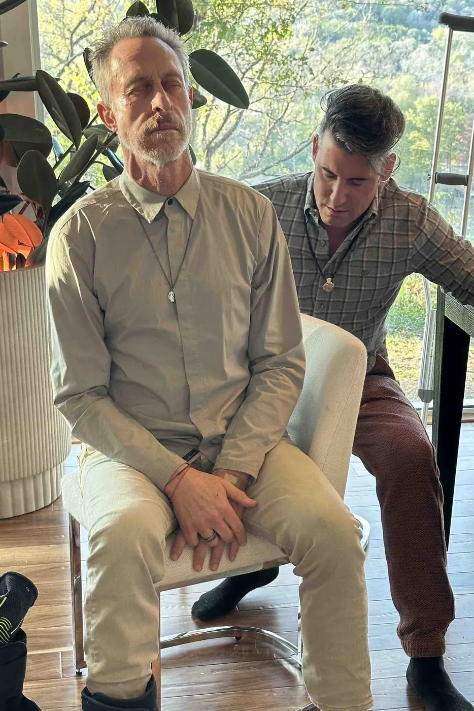 Joel treating Mark, who is seated wearing a walking boot